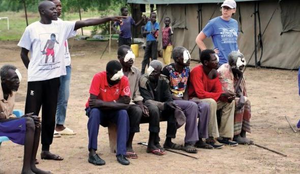 woman stands next to people sitting and one person pointing 